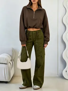 Woman wearing a dark brown half-zip cropped sweatshirt and olive green cargo pants