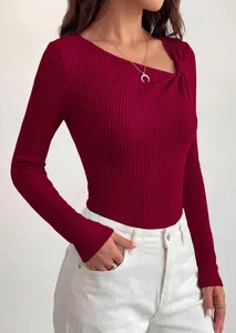 Close-up detail of burgundy ribbed knit top featuring asymmetrical twist knot neckline