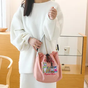 Détail du sac à déjeuner rose à cordon avec broderie de chiens mignons