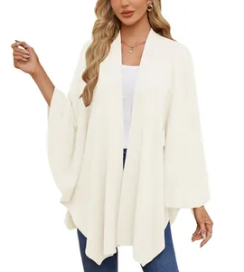 Vue détaillée d'un élégant châle poncho en tricot blanc cassé avec un drapé très doux
