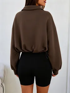 Back view of solid brown half-zip cropped sweatshirt with adjustable drawstring hem