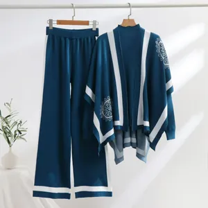 Elegantes blaues Strick-Set mit farblich abgesetztem Schal und Hose an Kleiderbügeln