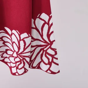 Vista macro dettagliata del motivo jacquard floreale bianco su morbido maglia rossa