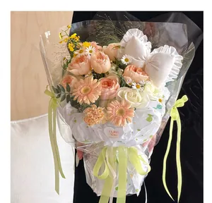 Bouquet de roses pêches emballé dans du papier poire à pois blancs et film clair