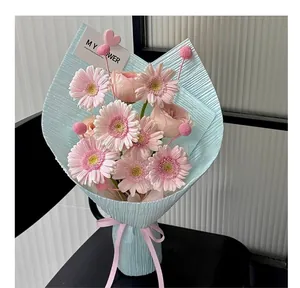 Detail view of light blue pleated crepe paper wrapping a fresh pink flower bouquet.