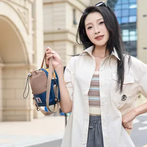 Mannequin présentant un petit sac à bandoulière d'extérieur bicolore pour voyage