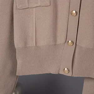 Detalle del tejido de punto y los botones dorados de una chaqueta de color marrón