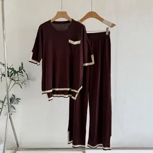 Close-up detail of women's burgundy knitted two-piece set featuring contrast stripes