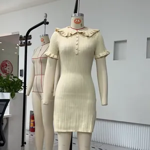 Robe courte en maille côtelée crème avec col Claudine à volants et manches courtes.