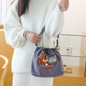 Vue détaillée du sac à déjeuner brodé de dessins animés japonais sur une épaule