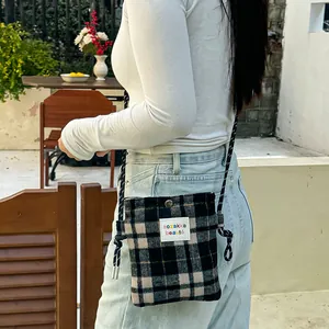 Stylish plaid wool crossbody bag for women worn by a model in a casual outdoor setting