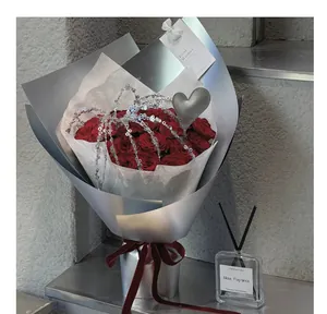 Dettaglio di un ornamento a cuore in pelle argentata e decorazione di perline in un bouquet.