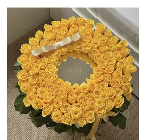 Detail of a luxury yellow rose wreath arrangement with a central mirror and brand ribbon