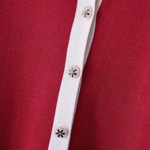 Primo piano dettagliato di bottoni metallici decorativi su una maglia rossa fitta