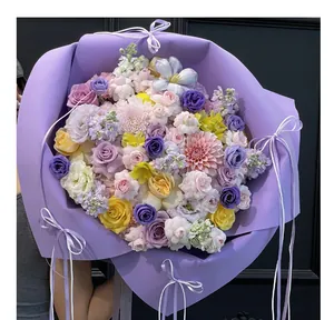 Détail du papier d'emballage en mousse violette sur un grand bouquet de fleurs mélangées