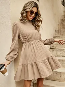 Detail eines eleganten khakifarbenen plissierten Minikleides mit Stehkragen und Rüschensaum