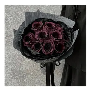 Detailed view of dark purple roses wrapped in elegant black pleated crepe flower paper