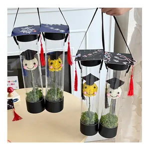 Detalle de cajas de regalo de flores cilíndricas de graduación con tapas de birrete