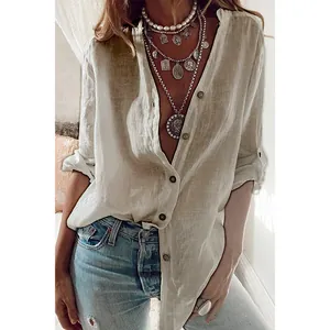 Détail d'une chemise ample en coton beige chic avec col en V profond et boutons nacrés