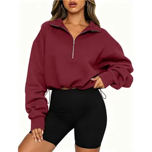 Detail view of a maroon half-zip cropped sweatshirt with a collar and adjustable drawstring