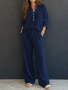 Detailed view of women's navy blue waffle knit lounge set with Henley collar and wide-leg pants