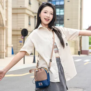 Sac à bandoulière léger pour téléphone et bouteille d'eau porté par un mannequin en ville