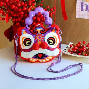 Close-up of traditional Chinese lion dance plush crossbody bag with festive red berries background.