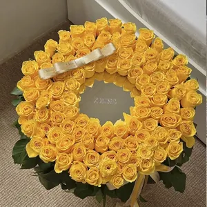 Elegant circular mirror flower box featuring vibrant yellow roses and decorative ribbon