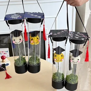 Caja de regalo creativa de flores de graduación con tapa de birrete y flor sonriente