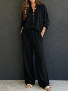Vista dettagliata del set relax nero in maglia a nido d'ape con scollo Henley e bottoni