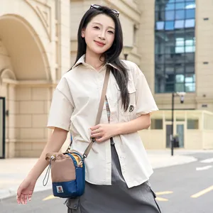 Vue de style de vie d'un sac à bandoulière léger pour bouteille d'eau porté dans la rue