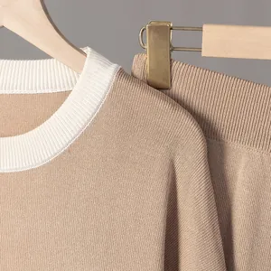 Primer plano de un conjunto de punto beige de alta calidad con cuello en contraste.