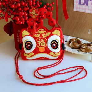 Detail of cute red plush crossbody bag with embroidered Chinese lion dance pattern