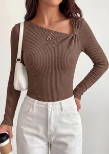 Detailed shot of woman wearing a brown ribbed knit top with asymmetrical twist neck