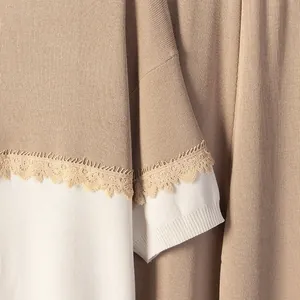 Detalle de los acabados de encaje delicado en este conjunto de punto bicolor a la moda.