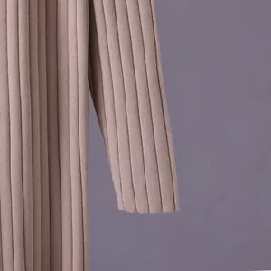 Close-up of soft ribbed knit sweater fabric showing elegant mauve texture detail