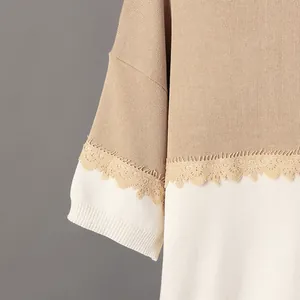 Detalle de punto bicolor con adorno de encaje floral y textura suave.