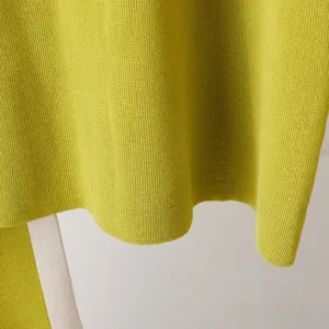 Close-up of lime green knit fabric texture showing fine stitching and hem detail