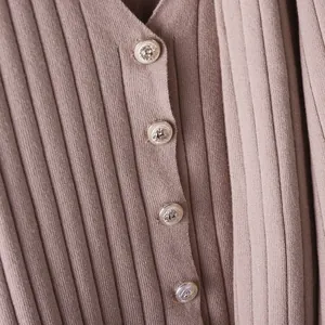 Detailed shot of soft mauve ribbed knit cardigan with elegant vintage metal buttons
