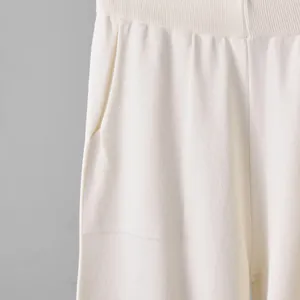 Primer plano de la cintura elástica y el bolsillo de los pantalones de punto blanco crema
