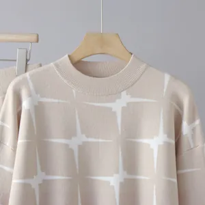 Macro view of beige knitted sweater detail featuring elegant white starburst jacquard pattern