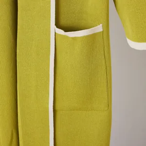 Detail view showing the knitted texture and white contrast trim on a green robe pocket