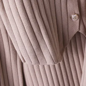 Close-up of premium ribbed knit fabric texture with a decorative silver embossed button