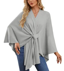 Détail d'un élégant poncho en tricot gris clair pour femme avec un design noué doux
