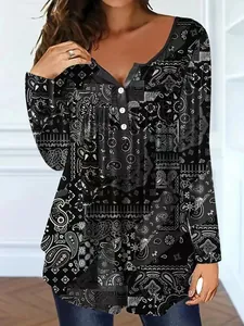 Detailed view of women's long sleeve tunic with black and white paisley print and buttons.