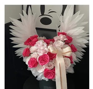 Bouquet di rose rosa fatto a mano con eleganti ali d'angelo bianche e fiocco in nastro crema