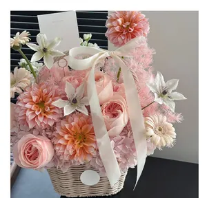 Elegant white handheld woven wicker flower basket with pink roses and cream ribbon bow