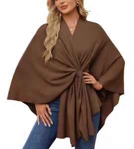 Un élégant châle poncho en tricot marron pour femme avec détail de nœud frontal