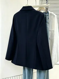 Back view of a navy blue slim-fit women's fashion blazer hanging on a rack