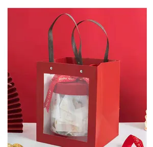 Detailed view of festive red New Year gift bag with a transparent window and decorative ribbon